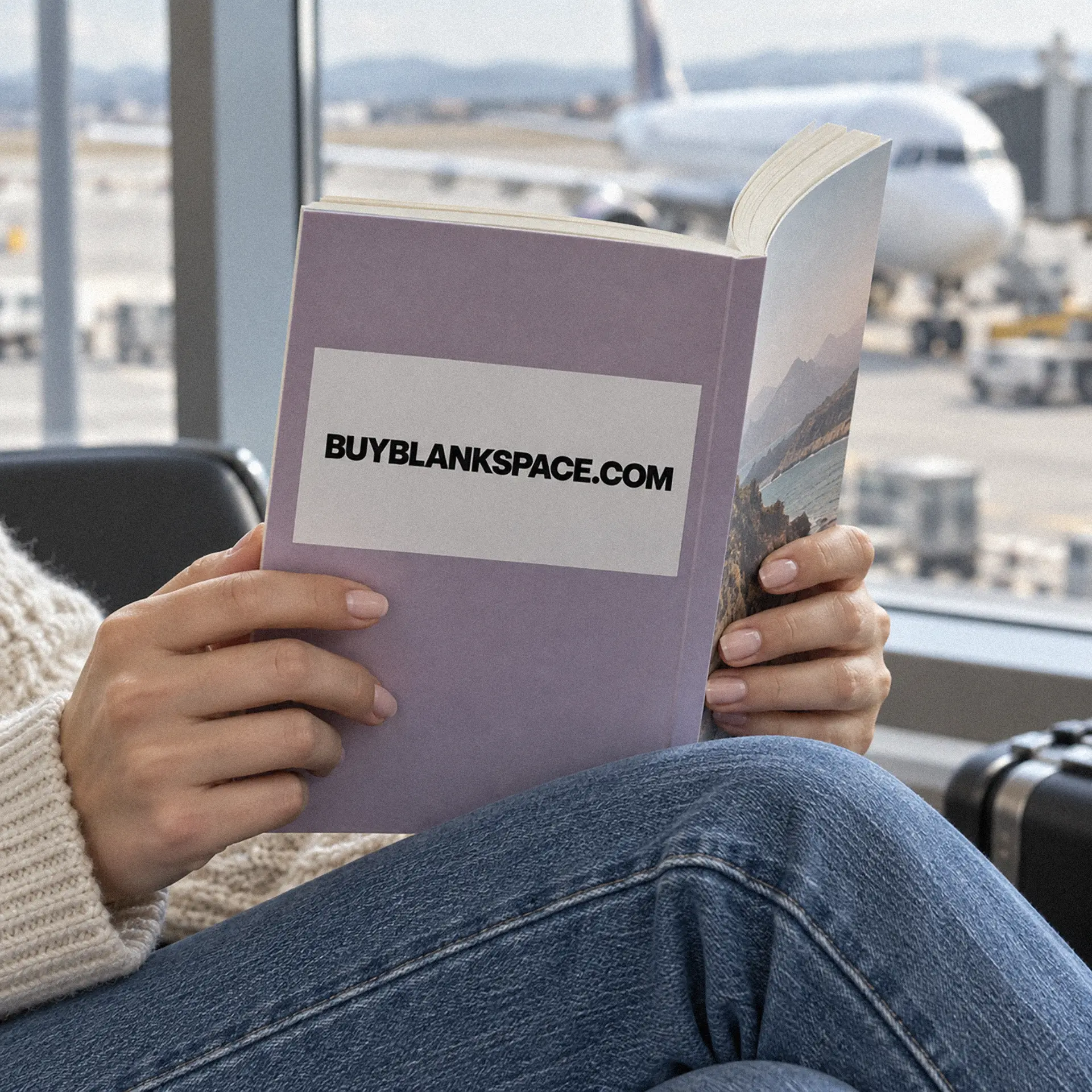 Travel book displaying BUYBLANKSPACE.COM beside an airport window